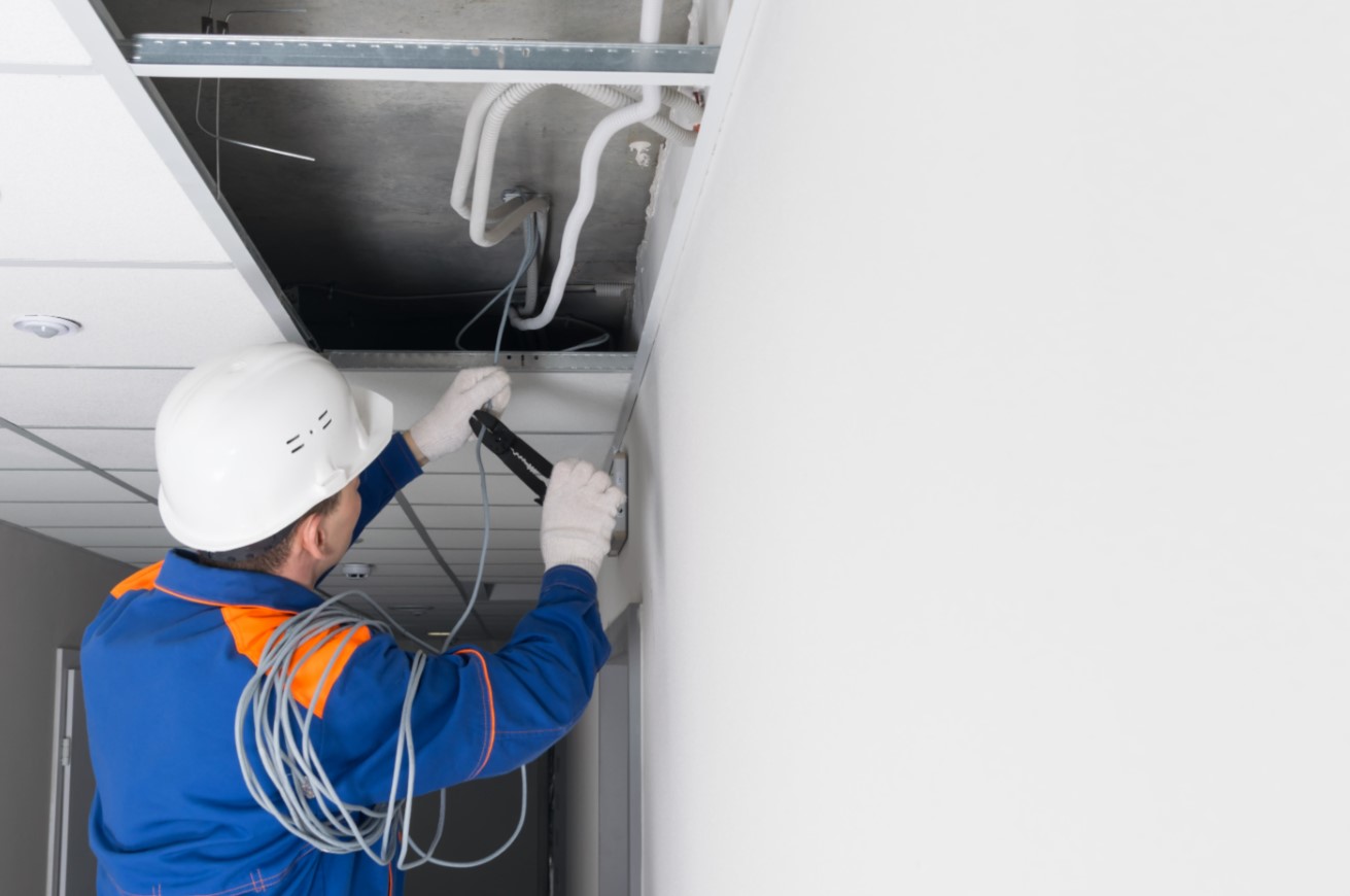 Electrician installing electrical wiring in commercial building