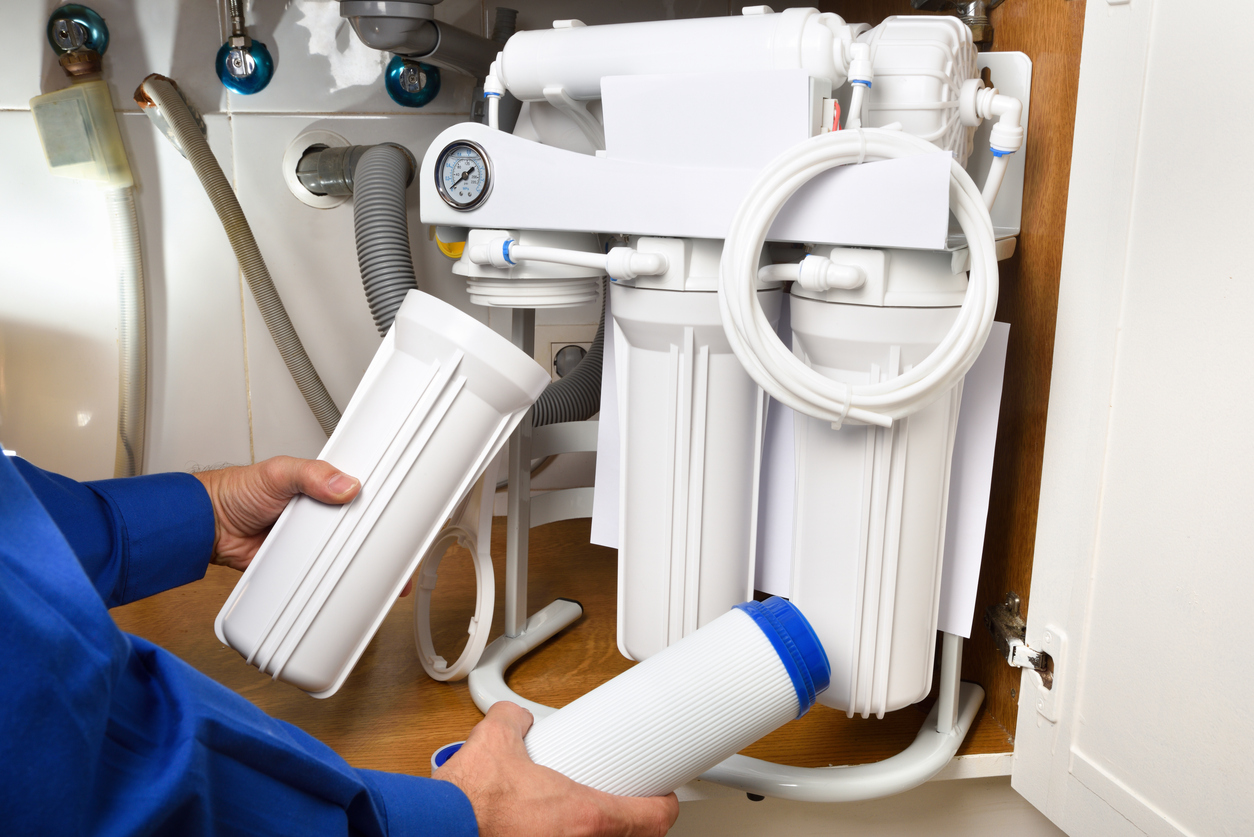 YES! plumber holding water filtration system in a Salt Lake City, UT, home. 