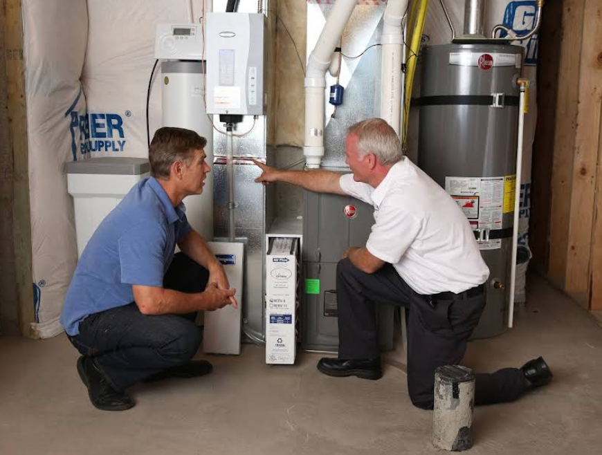 A YES! technician explains air filtration systems to a homeowner in a utility room in Las Vegas, NV.