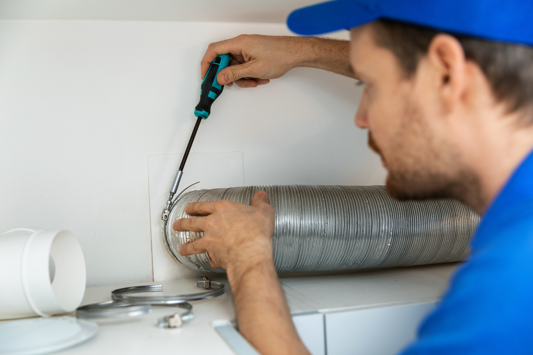 YES! technician repairing wall air duct at home in Salt Lake City, UT, with tools.