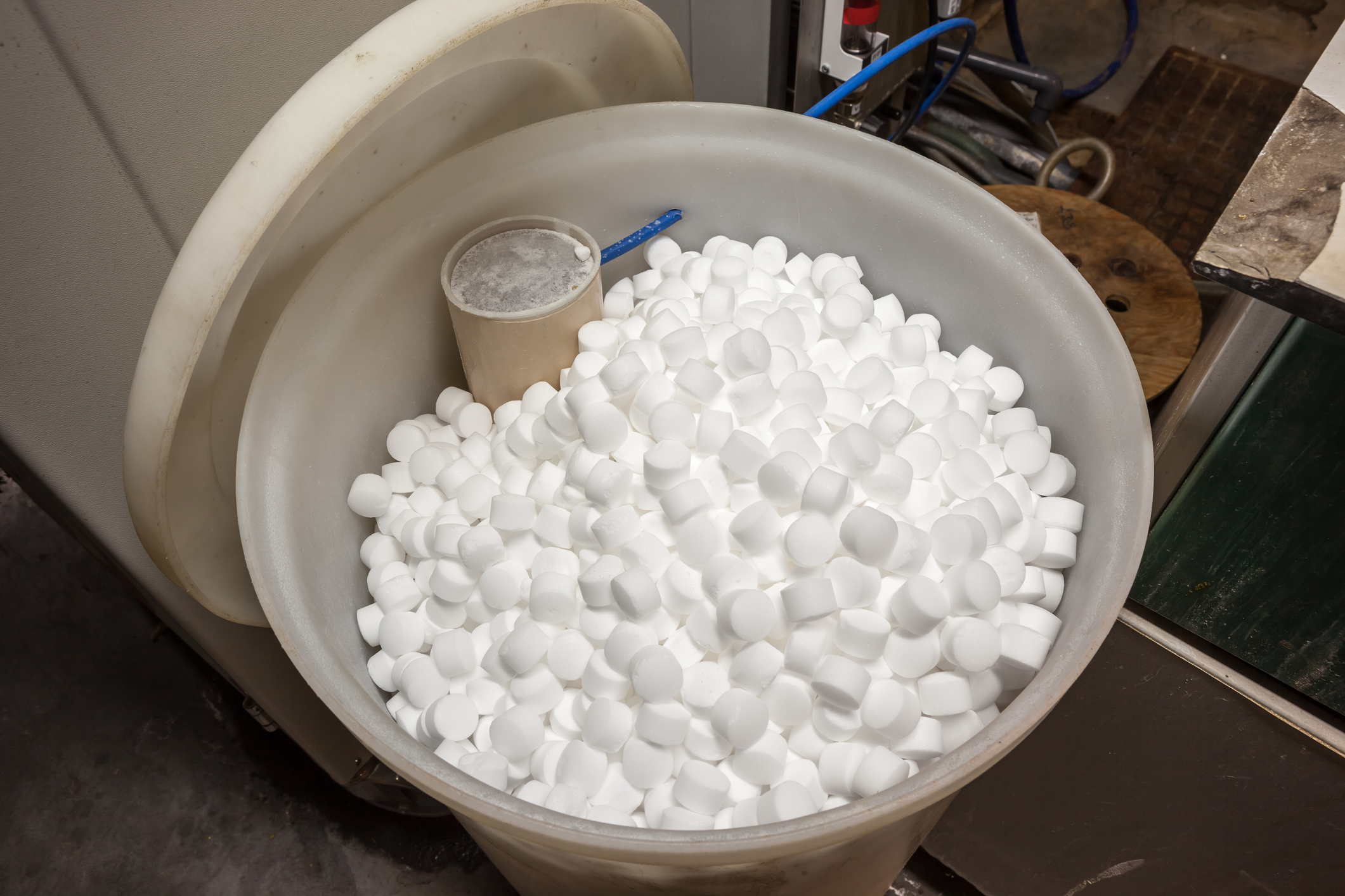 An open water softener with visible salt blocks inside