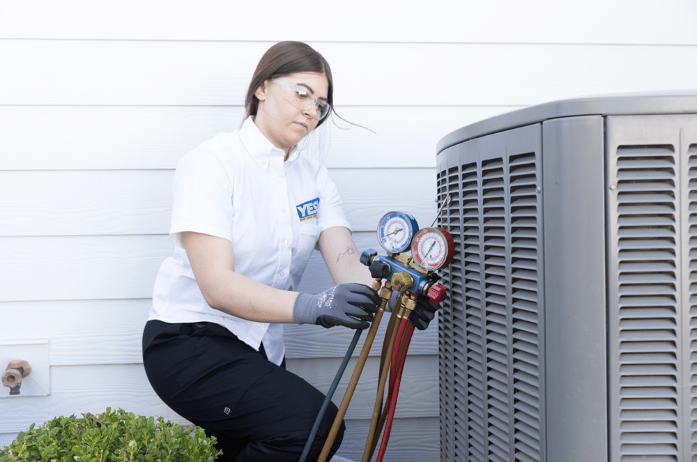 Woman testing outdoor HVAC equipment with a pressure tool for HVAC maintenance at a home in Las Vegas, NV.
