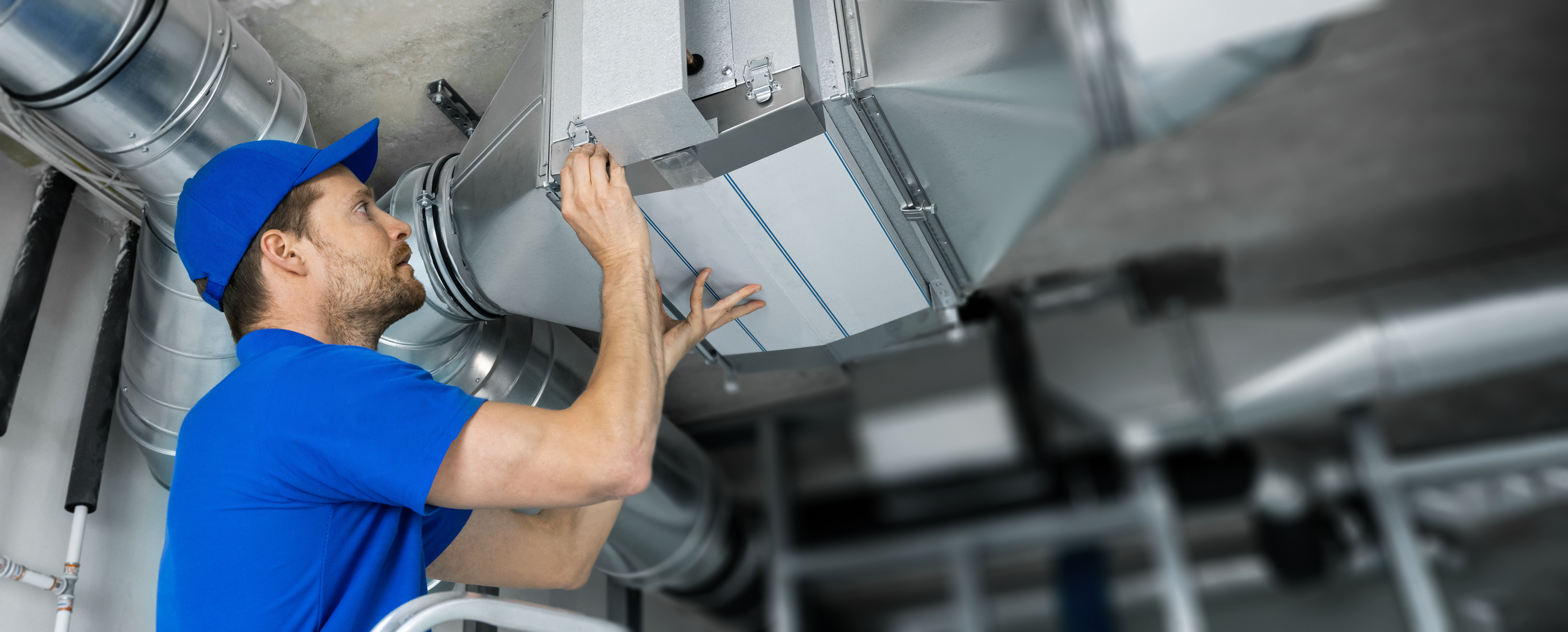 YES! technician holding and repairing an air duct system in a Las Vegas building. 